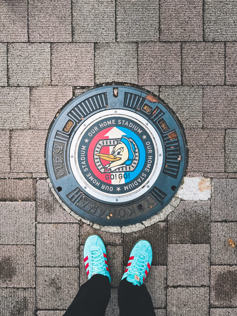 Decorative manhole cover guiding visitors to Nissan Stadium in Yokohama